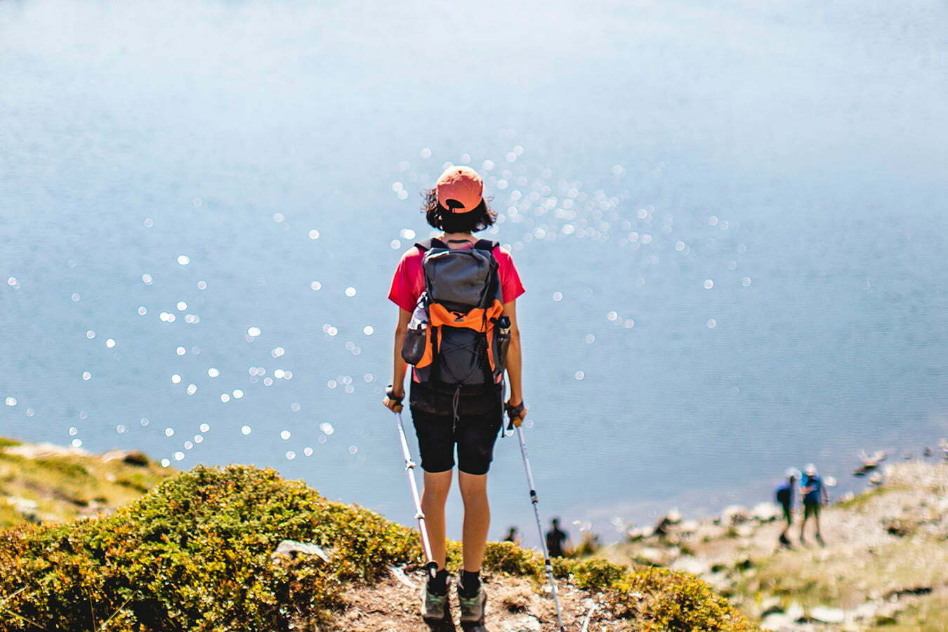 person atop a hill over looing the ocean