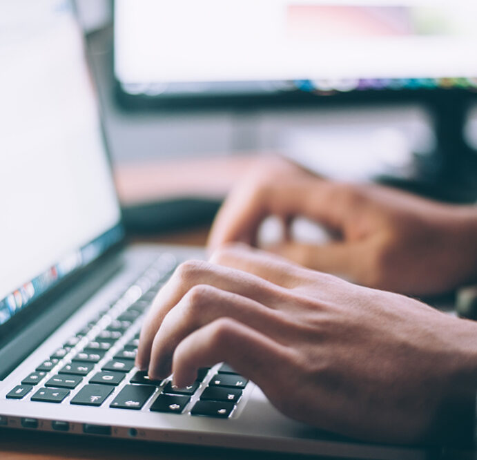 hands typing on a laptop